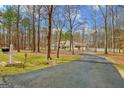 View of home down long driveway through a wooded landscape at 106 Robinson Bend Trl, Peachtree City, GA 30269