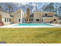 Backyard pool with a stone fireplace and outdoor seating area at 106 Robinson Bend Trl, Peachtree City, GA 30269
