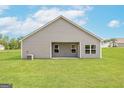 Back of home and yard featuring a covered patio area and manicured lawn at 909 Hesston Dr, Locust Grove, GA 30248