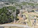 Aerial view of a 1.88 acre property with a home nestled amongst mature trees and expansive green space at 74 Price W Dr, Locust Grove, GA 30248