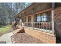 Welcoming covered front porch with brick siding and a charming entrance, complete with Georgia Bulldogs decor at 74 Price W Dr, Locust Grove, GA 30248