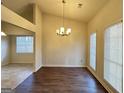 Well-lit dining room with dark wood flooring, chandelier, and large windows at 3750 Greenbrook Dr, Douglasville, GA 30135