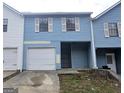 Exterior of a two-story condo with a garage and blue siding, offering a cozy and inviting curb appeal at 905 Pine Tree Trl, South Fulton, GA 30349