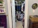 Packed walk-in closet with hanging clothes, shelves, and overhead storage at 24 Picketts Mill Pl, Acworth, GA 30101