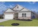 Attractive single-story home with a lush green lawn and a young tree in the front yard at 3382 Arabian Farm Ln, Dacula, GA 30019