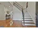 Open foyer with hardwood floors and staircase with iron railings, leading to the upper level at 115 Ashton Park, Peachtree City, GA 30269