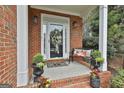 Inviting front porch with decorative wreath, bench, and potted plants creating a welcoming entrance at 115 Ashton Park, Peachtree City, GA 30269