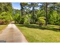 Long driveway leading to a private home surrounded by lush greenery and mature trees, creating a serene setting at 160 Pine Trail Rd, Fayetteville, GA 30214