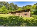 Well-maintained brick house with visible window shutters, set on a spacious lot with mature trees offering shade at 160 Pine Trail Rd, Fayetteville, GA 30214