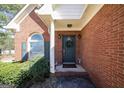 Close up of brick house entry showcasing covered porch, wreath on door and a window beside the door at 1800 Stockton Walk Ln, Snellville, GA 30078