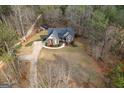 Aerial view of a lovely home with a circular driveway amidst a beautiful landscape and mature trees at 172 Sam Solomon Rd, Locust Grove, GA 30248