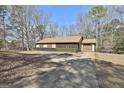 Ranch style home with a screened in porch, driveway, and partial view of the yard at 439 Elder St, Fairburn, GA 30213