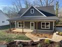 Gray home with a covered front porch, complemented by a stone walkway and landscaped garden at 5232 West Mountain Street, Stone Mountain, GA 30083