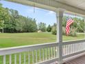 View from the covered front porch overlooking a sprawling, green front yard at 2110 Mcgarity Rd, Mcdonough, GA 30252