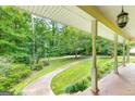 Covered front porch showcasing a beautiful view of the lush, green front yard and mature trees at 437 Forrest Ave, Fayetteville, GA 30214