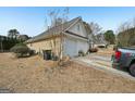 Side view of home, with 2 car garage, and beige vinyl siding in backyard at 306 Preston Chase Dr, Peachtree City, GA 30269