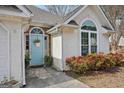 Close-up of home's entrance featuring a light blue door, brick detail, and landscaped walkway to the main entrance at 306 Preston Chase Dr, Peachtree City, GA 30269