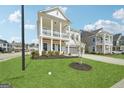 Beautifully landscaped lawn and view of the charming two-story home with double front porches at 401 Hallman Pl, Peachtree City, GA 30269