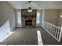 Cozy living room with a stone fireplace, large windows, and neutral-toned carpet at 2930 David Ne Ln, Conyers, GA 30012