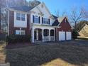 Charming two-story home with a brick and siding exterior, complemented by a cozy front porch at 5725 Lake Windsor Pkwy, Buford, GA 30518