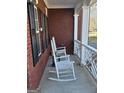 Close-up of front porch with white rocking chairs and brick facade for a relaxing outdoor experience at 5725 Lake Windsor Pkwy, Buford, GA 30518