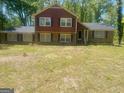 Charming two-story home with brick and wood exterior, large front yard, and mature trees at 392 N Hwy 314, Fayetteville, GA 30214