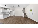 Open-concept living space showcases wood floors, modern lighting, and entry to the kitchen at 1081 E Lake Road, Mcdonough, GA 30252
