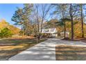 Inviting home exterior with a long driveway, metal carport, and beautifully landscaped yard at 75 Antioch Rd, Mcdonough, GA 30252