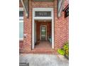 Inviting entryway with brick floor, front door with transom, and house number display at 9135 Selborne Ln, Chattahoochee Hills, GA 30268