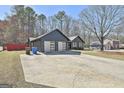 Long driveway with gray home with white garage doors and double front doors, and detached structure at 203 Hedgewood Ct, Peachtree City, GA 30269