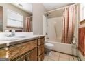 Bathroom featuring wood vanity, sink, and a shower-tub combination with an orange curtain at 5365 Renault St, Cumming, GA 30041