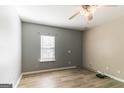 Spacious bedroom with natural light, ceiling fan, and neutral paint, plus wood-look laminate flooring at 5365 Renault St, Cumming, GA 30041