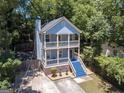 Charming two-story home with blue siding and double balconies, nestled amongst mature trees at 1103 Coleman Sw St, Atlanta, GA 30310