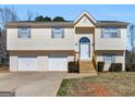 Attractive split-level home features a two-car garage, wood stairs and tidy landscaping at 195 Brighton Dr, Covington, GA 30016