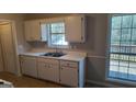 Well-lit kitchen with stainless steel sink, white cabinets and appliances and window with a view at 97 Arnold Rd, Hampton, GA 30228