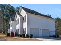 Exterior view of the home showcasing an attached two car garage and manicured landscaping at 231 Ashley Trace Dr, Locust Grove, GA 30248