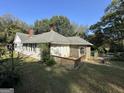 View of the rear of the home, featuring a wooden deck and screened-in porch at 3 Elm St, Porterdale, GA 30014