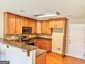 Functional kitchen features wooden cabinets, modern appliances, and a breakfast bar, perfect for casual dining at 1029 Hines Rd, Moreland, GA 30259