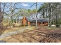 A cozy brick house sits nestled among mature trees and greenery at 105 Jasper Dr, Stockbridge, GA 30281