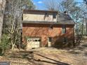 Back exterior with brick and tan vinyl siding, garage door, door and windows at 105 Jasper Dr, Stockbridge, GA 30281