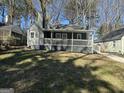 Charming gray home featuring a covered front porch, a well-maintained lawn, and mature trees at 1457 Richland Sw Rd, Atlanta, GA 30310