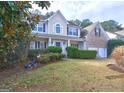 Inviting two-story home with a well-kept lawn, mature trees, and a charming covered front porch at 976 Buckhorn Bnd, Locust Grove, GA 30248