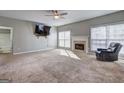 Spacious living room features a fireplace, neutral carpet, and great natural light from the windows at 976 Buckhorn Bnd, Locust Grove, GA 30248