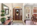 Elegant foyer with decorative glass front door, tile flooring, and stylish table and mirror at 417 Harper Rd, Mcdonough, GA 30252