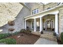 Inviting front porch with classic columns, seating area, and charming decor, offering a warm welcome at 415 Oxmoor Lake Dr, Mcdonough, GA 30252