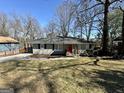 Charming single-story home boasts a well-manicured lawn and mature trees providing shade at 791 Gertrude Nw Pl, Atlanta, GA 30318