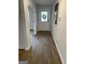 Inviting hallway with wood floors, white trim, and a door with a wreath, leading to other rooms at 742 Great Oak Pl # 13, Villa Rica, GA 30180
