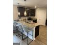 Stylish kitchen featuring a breakfast bar with pendant lighting, dark cabinets, and modern appliances at 742 Great Oak Pl # 13, Villa Rica, GA 30180