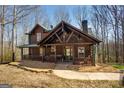 Inviting log cabin with a covered porch, showcasing its rustic charm and natural setting at 1225 Pitts Chapel E, Newborn, GA 30056