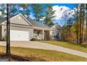 A single-Gathering home featuring a two-car garage, stone accents, and a charming front porch at 460 Carrie Kathleen Ter, Carrollton, GA 30116